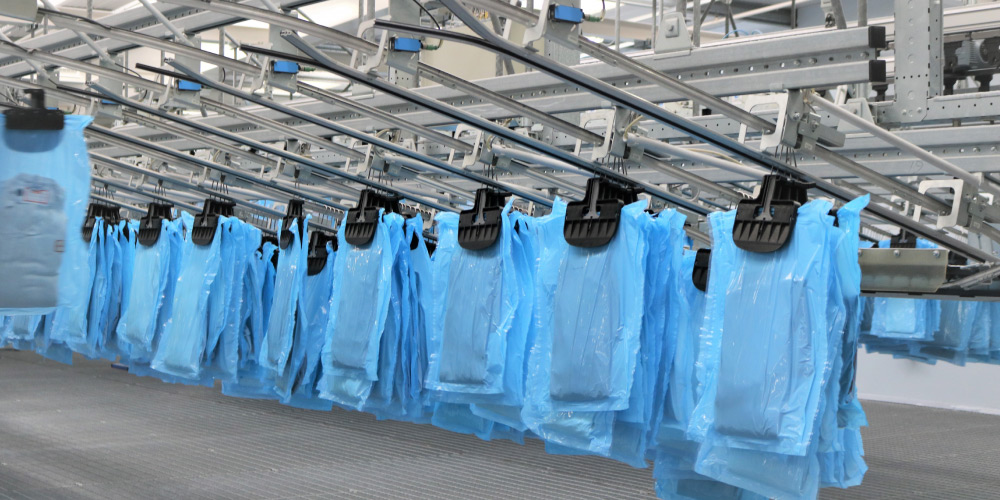 Packed hanging garments on a hanging conveyor system at Micronclean