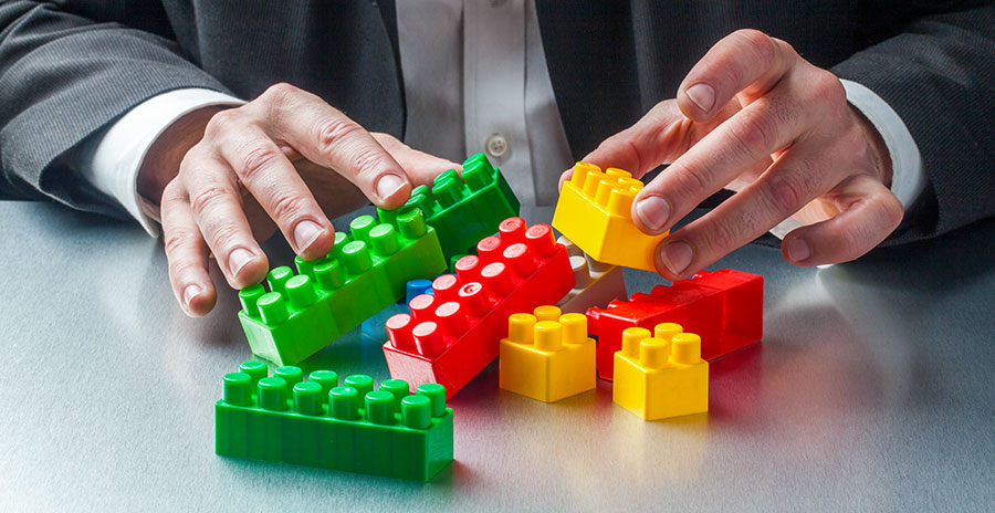 A Businessman assembling Lego pieces