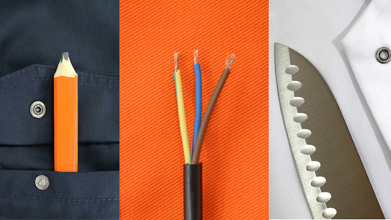 Ein Bleistift, Elektrokabel und ein Messer in den Taschen eines gut sichtbaren Arbeitsanzugs