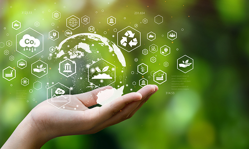 A hand holding green technology related icons.